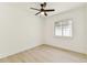 Bright bedroom features light wood flooring, a ceiling fan, and a window with natural light at 13835 Pathfinder Dr, Tampa, FL 33625
