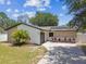 Charming single-story home with a well-manicured lawn, solar panels, and a driveway at 13835 Pathfinder Dr, Tampa, FL 33625