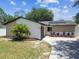 Charming single-story home with xeriscaped garden and driveway leading to the entrance at 13835 Pathfinder Dr, Tampa, FL 33625