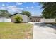 Beautiful front yard with landscaping, healthy lawn, paved driveway, and white fence at 13835 Pathfinder Dr, Tampa, FL 33625