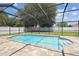A screened-in pool with light blue water is surrounded by a brick patio and green grass at 13835 Pathfinder Dr, Tampa, FL 33625