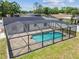 An aerial view of a screened pool with a brick surround, perfect for outdoor enjoyment at 13835 Pathfinder Dr, Tampa, FL 33625