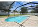 A screened-in pool with light blue water is surrounded by a brick patio and green grass at 13835 Pathfinder Dr, Tampa, FL 33625