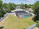 Aerial view of backyard featuring a screened pool, patio, fire pit and grassy area at 13835 Pathfinder Dr, Tampa, FL 33625