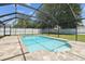 A screened-in pool with light blue water is surrounded by a brick patio and green grass at 13835 Pathfinder Dr, Tampa, FL 33625