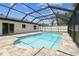 A screened-in pool with light blue water is surrounded by a brick patio and green grass next to the house at 13835 Pathfinder Dr, Tampa, FL 33625