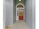 Close-up of a striking red front door with decorative glass panels at 15615 Indian Queen Dr, Odessa, FL 33556