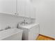 Well-lit laundry room with washer, dryer, sink and ample cabinet space at 15615 Indian Queen Dr, Odessa, FL 33556