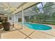 Screened-in pool area with blue water and lush greenery in the background at 15615 Indian Queen Dr, Odessa, FL 33556