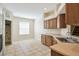 Open kitchen features light-colored countertops, and a tiled floor looking towards laundry room at 15841 Pond Rush Ct, Land O Lakes, FL 34638