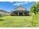 A fenced backyard featuring an extended screened-in lanai with ample lawn space for outdoor activities at 17510 Bright Wheat Dr, Lithia, FL 33547
