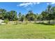 Spacious backyard showing the well-maintained lawn, mature trees, and a classic white picket fence at 17510 Bright Wheat Dr, Lithia, FL 33547