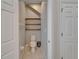 Bright half bathroom featuring a toilet, tile flooring, and decorative wooden shelves at 17510 Bright Wheat Dr, Lithia, FL 33547