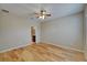Bedroom featuring hardwood floors, ceiling fan, and ensuite half bathroom at 17510 Bright Wheat Dr, Lithia, FL 33547