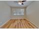 This large, empty bedroom has a ceiling fan, window and wood flooring at 17510 Bright Wheat Dr, Lithia, FL 33547