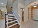 Hallway view with tiled floors, staircase with wood treads, and entry to half bathroom at 17510 Bright Wheat Dr, Lithia, FL 33547