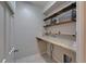 Functional laundry room with granite countertop, shelving, and tile floors at 17510 Bright Wheat Dr, Lithia, FL 33547