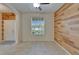 Well-lit room with a stunning wood accent wall and tiled flooring at 17510 Bright Wheat Dr, Lithia, FL 33547