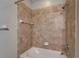 Shower with beige tile, white fixtures, and a showerhead at 17510 Bright Wheat Dr, Lithia, FL 33547