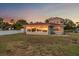 Back of home featuring ample backyard space, large windows, and sunset reflection at 1963 Edgewater Dr, Clearwater, FL 33755