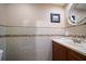 Elegant half bath with decorative tile accents, stylish vanity and sink, and a framed mirror at 1963 Edgewater Dr, Clearwater, FL 33755