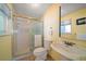 Bathroom with tiled shower and gold trim, white pedestal sink and toilet at 1963 Edgewater Dr, Clearwater, FL 33755