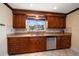 Kitchen boasting custom wood cabinetry, tile backsplash, and a stainless steel dishwasher at 1963 Edgewater Dr, Clearwater, FL 33755