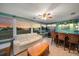 Inviting sunroom with waterfront views, comfortable seating, bar, and a ceiling fan at 1963 Edgewater Dr, Clearwater, FL 33755