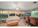 Inviting sunroom with waterfront views, comfortable seating, bar, and a ceiling fan at 1963 Edgewater Dr, Clearwater, FL 33755