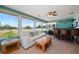 Inviting sunroom with waterfront views, comfortable seating, bar, and a ceiling fan at 1963 Edgewater Dr, Clearwater, FL 33755