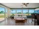 Bright sunroom featuring panoramic water views, comfortable seating, and tile floors at 1963 Edgewater Dr, Clearwater, FL 33755