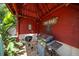 Close-up of the tiki bar featuring a built-in grill, decorative signage, and tropical plants at 1963 Edgewater Dr, Clearwater, FL 33755