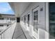 White painted hallway with white railing and blue sky, leading to the condo entrances in a well maintained community at 2002 Australia E Way # 66, Clearwater, FL 33763