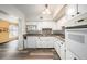A bright kitchen featuring white cabinets, granite countertops, modern appliances, and wood-look flooring at 2002 Australia E Way # 66, Clearwater, FL 33763