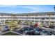 View of complex featuring a parking lot and tropical landscaping, complete with palm trees at 2002 Australia E Way # 66, Clearwater, FL 33763