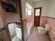 Pink tiled bathroom with a tub, toilet, and partially demoed walls at 2100 Pass A Grille Way, St Pete Beach, FL 33706