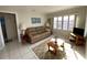 Bright living room featuring tile floors, a comfy leather sofa, and a large window with natural light at 2100 Pass A Grille Way, St Pete Beach, FL 33706
