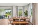 Bright dining room with wood table, bench, and chairs near sliding glass doors to outdoor seating area at 2286 Sienna Spruce St, Wesley Chapel, FL 33543
