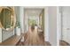 Inviting hallway with wood floors, green accent walls, stylish decor, and a view into the living area at 2286 Sienna Spruce St, Wesley Chapel, FL 33543