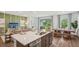 Modern kitchen overlooking an open concept living and dining area with large windows and decor at 2286 Sienna Spruce St, Wesley Chapel, FL 33543