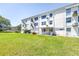Back of building featuring green lawn and private patios at 2452 Brazilia Dr # 18, Clearwater, FL 33763