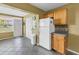 Practical kitchen area featuring a white refrigerator, storage cabinetry, and entrance to the front entryway at 2452 Brazilia Dr # 18, Clearwater, FL 33763