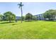 The expansive lawn area features trees and the condo buildings in the background at 2452 Brazilia Dr # 18, Clearwater, FL 33763