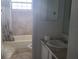 A bathroom with a bathtub and shower with curtain plus a vanity with sink at 2603 Mary Sue Sw St, Largo, FL 33774