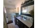 Bright bathroom featuring a shower with glass doors, decorative wall art and a sink with dark cabinetry at 314 Bloomingfield Dr, Brandon, FL 33511
