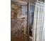 Modern shower featuring travertine tile, a sleek showerhead, and glass shelving, providing a spa-like experience at 314 Bloomingfield Dr, Brandon, FL 33511
