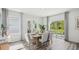 Elegant dining room with a table set for six, large windows, and hardwood floors at 32702 Winterwood Blvd, Wesley Chapel, FL 33543