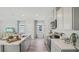 Modern kitchen with stainless steel appliances, an eat-in bar, and a view into the living area at 32702 Winterwood Blvd, Wesley Chapel, FL 33543
