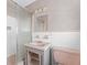 Retro bathroom with pink accents, including the sink, toilet, and patterned wallpaper at 5 Marina Ter, Treasure Island, FL 33706