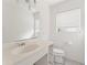 Bathroom with a single sink vanity, toilet, and a window with blinds allowing natural light at 5 Marina Ter, Treasure Island, FL 33706